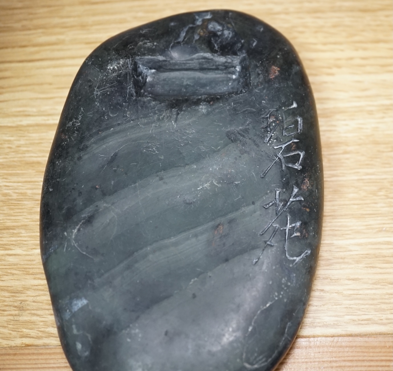 A Chinese literati ink stone with calligraphy, 16cm wide. Condition - fair